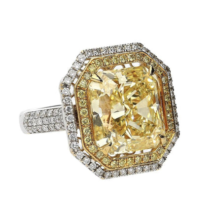 Gold ring with a large yellow gemstone and diamond-studded band on a white background